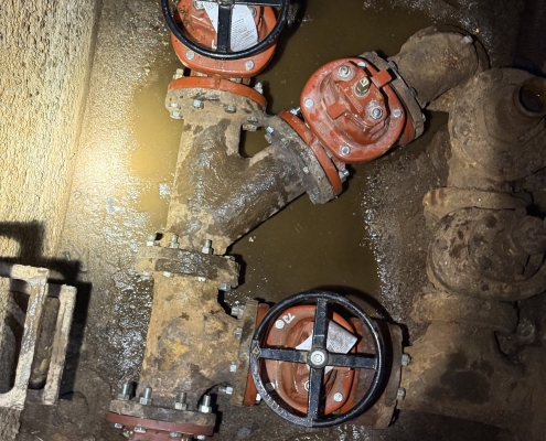 Close-up of gate valves and piping during a pump station service call